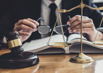 Male lawyer or judge working with contract papers, Law book and wooden gavel on table in courtroom, Justice lawyers at law firm, Law and Legal services concept.