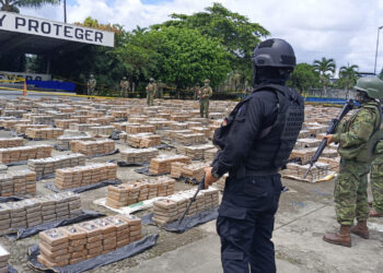 Members of the police and the Army present the 22 tons of drugs seized after an operation in Quevedo, Ecuador on January 22, 2024. - The cocaine seized in a mega military operation over the weekend increased from 10 to 22 tons, reported this Monday the Ecuadorian Army, deployed throughout the country in the framework of a war against drug gangs. (Photo by Daniel Vite / AFP)